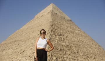 Person posing in front of a large pyramid.