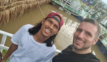 Two people standing near a river.