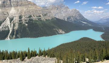 A large turquoise lake surrounded by forested mountains.