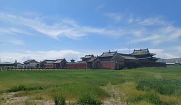Historical architecture in a grassy plain under a blue sky.