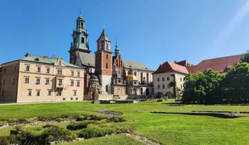 A historic castle-like building with grassy surroundings.