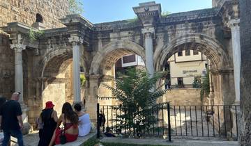 Historical arch with people sitting nearby.
