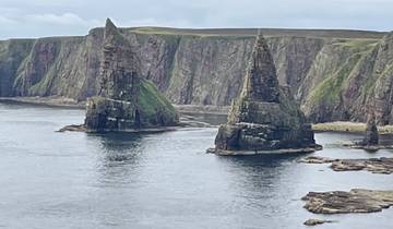 Dramatic coastal landscape with tall rock formations.