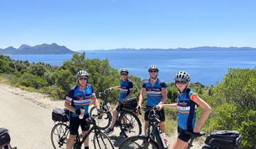 Group of cyclists taking a break with a scenic sea view.