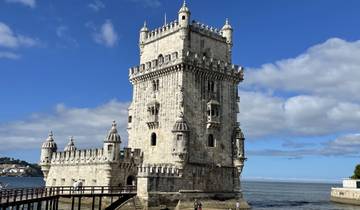 Historical tower by the water with clear sky.