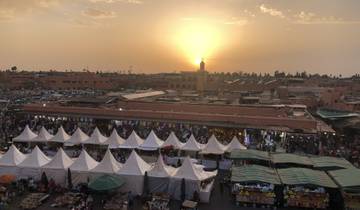 A bustling market with tents and people at sunset.