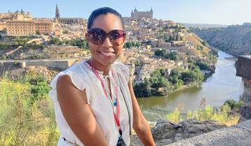 Woman enjoying a scenic overlook with a historical city in the background.
