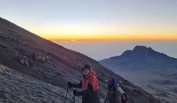 Hikers enjoying a sunrise view from a mountain.