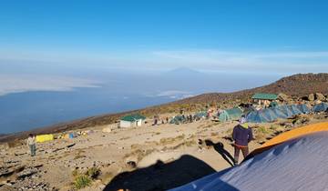 People camping in a mountainous area with tents.
