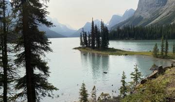 Serene lake with small island and mountains.