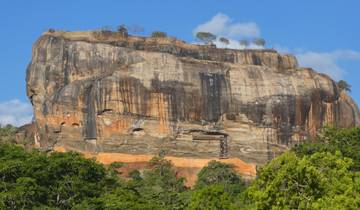 Sigiriya Rock Fortress standing tall amidst greenery.