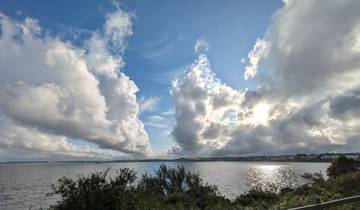 Dramatic skies over a calm body of water.