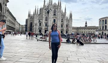 Woman posing in front of the Milan Cathedral in a busy plaza.