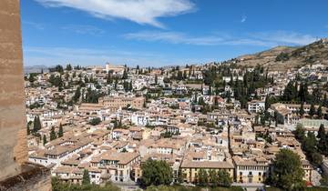 Panoramic view of a city with traditional architecture and hills.