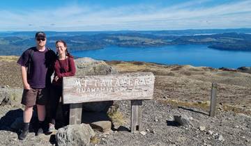 Couple posing at the top of Mt Tarawera with a scenic view.