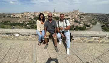 Three people posing with a cityscape in the background.
