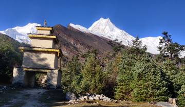 Mountainous landscape with temple and snowcapped peaks.