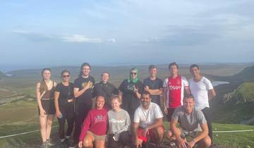 A group of people posing on a scenic hilltop with a wide landscape view.