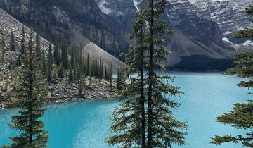 Turquoise lake with surrounding mountains and forests.