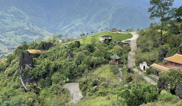 Lush green hills with pathways and small structures.