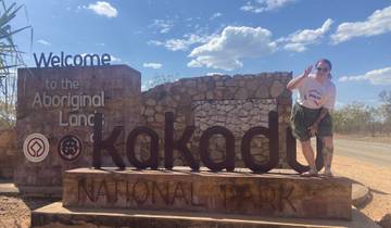 Person posing by the sign of Kakadu National Park.