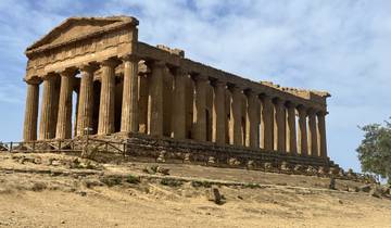 Ancient Greek-style temple ruins under a clear sky.