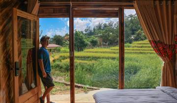Person standing in a room with view of rice fields.