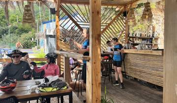 Bar with cyclists taking a break, including helmets and cycling gear.