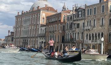 Venetian gondolas on a canal with historic buildings in the background.