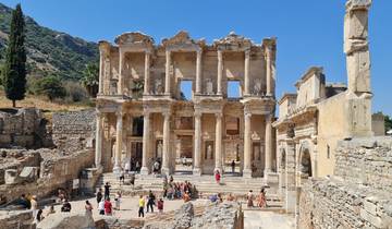 The ancient ruins of a library with many visitors.