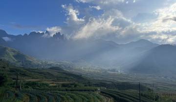 Beautiful landscape with mountains and mist under dramatic sky.
