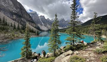 Pristine lake surrounded by mountains with hikers in the foreground.