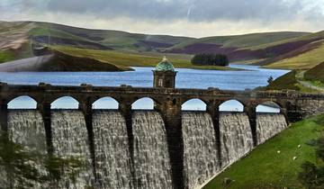 Reservoir with an arched dam surrounded by hills.