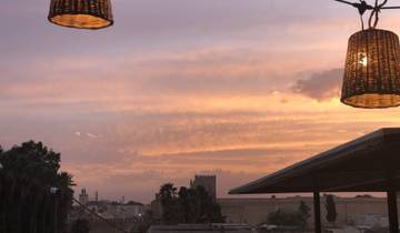 Scenic sunset over a city with orange and pink hues in the sky.