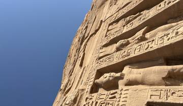 Close-up of hieroglyphics and carvings on an ancient stone wall.