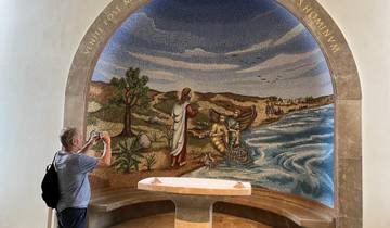 Religious mosaic in a chapel with a man taking a photo.