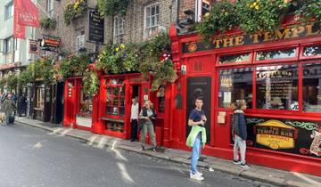 Colorful pub front of the Temple Bar in Dublin with people outside.
