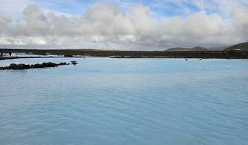 Wide view of a blue lagoon amid rocky landscape.