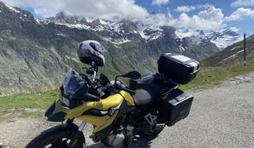 A motorcycle parked with snowy mountain views.