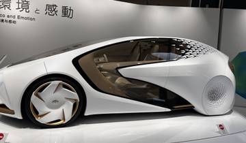 Futuristic concept car on display with Japanese text.