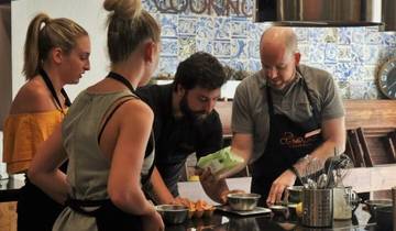 Group of people participating in a cooking class with tiled walls in the background.