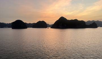 Scenic view of a bay at sunset with rock formations.