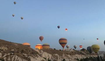 Hot air balloons floating above a rocky terrain.