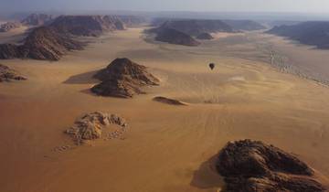 Sweeping aerial view of Wadi Rum desert with hot air balloon