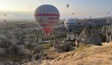 Hot air balloons floating above rocky landscape