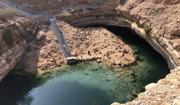 Natural sinkhole filled with water and surrounded by rocks.