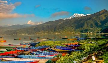 Colorful boats on a lake with mountains in the background.