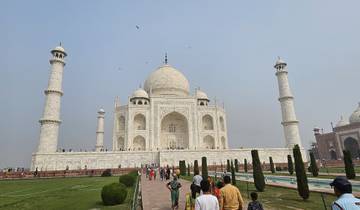 Taj Mahal with gardens and visitors.