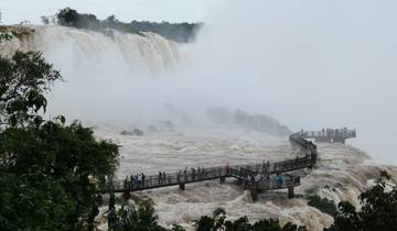 Walkway through powerful waterfalls with mist.