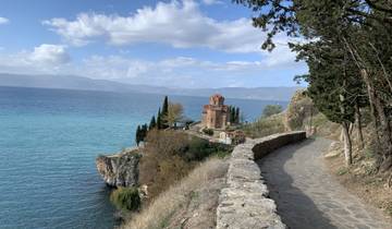 Scenic view of a church on a cliff by the sea with a stone pathway.
